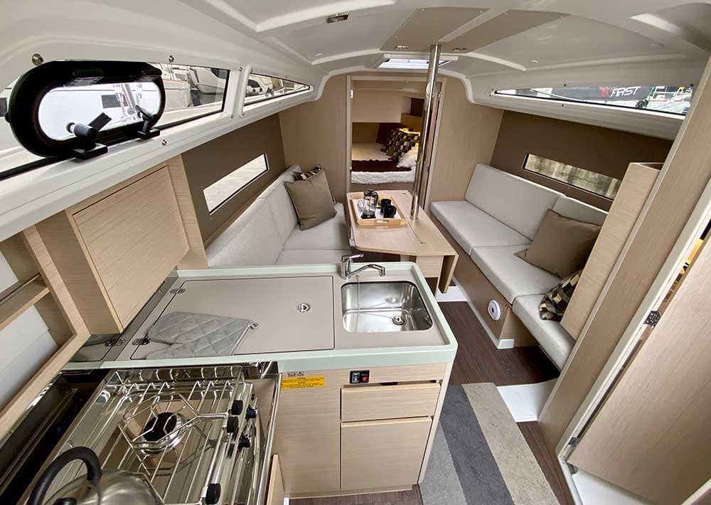 Cocina del Oceanis 30.1 con fogones, fregadero y salón